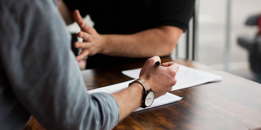 hands of person explaining and of another person writing