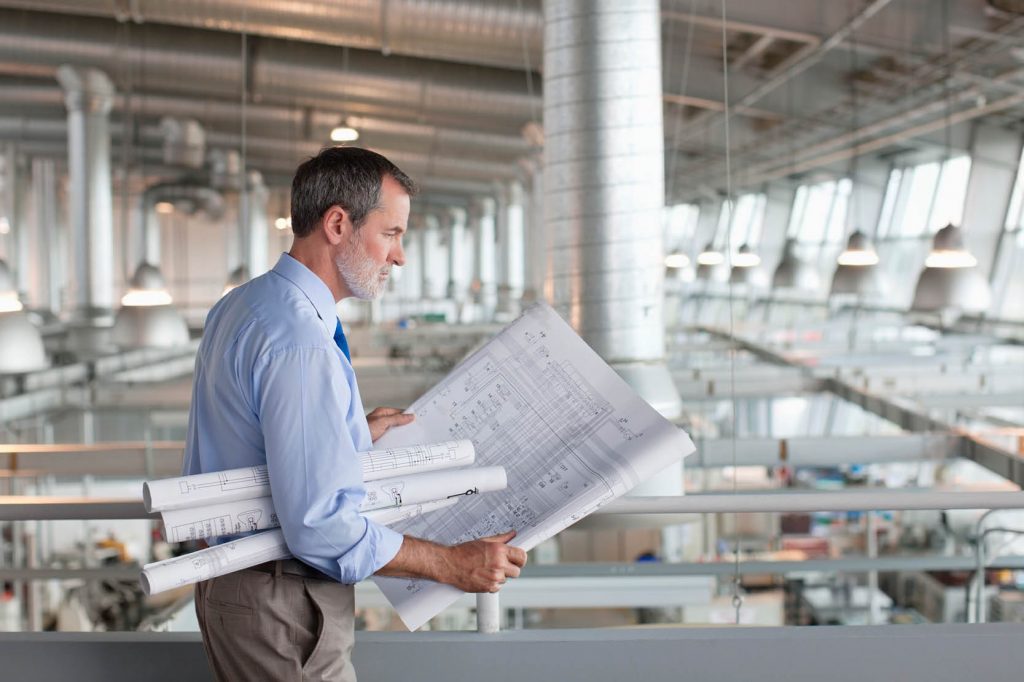 man reviewing plan drawings in office